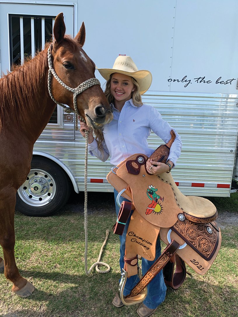 Brilee Cochran shows off the saddle she won as the State Cutting Champion.